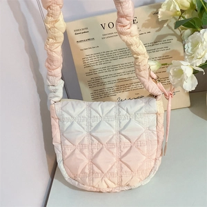 Detail of pink gradient quilted shoulder bag featuring pleated strap and flap design