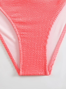 Macro shot of pink bikini bottoms featuring crinkle texture fabric and soft inner lining