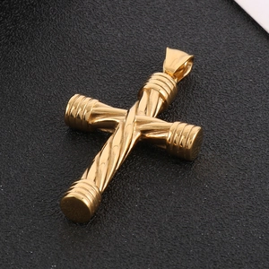 Macro view of gold twisted cable cross pendant with smooth ends on black background