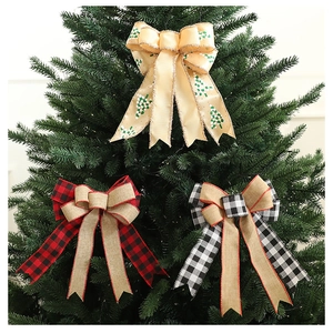 Close-up of festive plaid and printed Christmas bows decorating a green Xmas tree branch