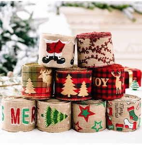 Detailed view of burlap Christmas ribbons with festive reindeer and berry patterns