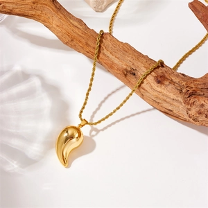 Golden twist chain necklace with a drop pendant on white background with sea shells
