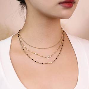 Detailed close-up of layered Egyptian Ankh necklace with white and black seed beads