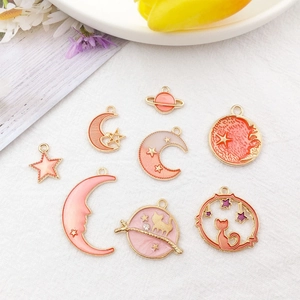 Close-up of pink enamel star moon and cat charms for DIY jewelry making accessories