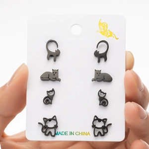 Macro detail of four pairs of black stainless steel cat earrings on a display card