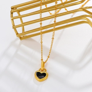 Elegant gold chain necklace featuring a black heart pendant with metallic bead trim