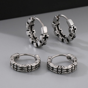 Detail of vintage silver hoop earrings with hollow cross and floral engraving designs