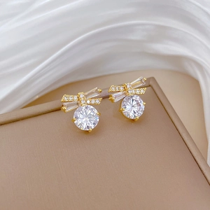 Detailed close-up of butterfly stud earrings with round cubic zirconia on silk