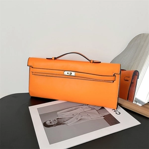 Elegant orange leather long clutch handbag with classic turn-lock and top handle