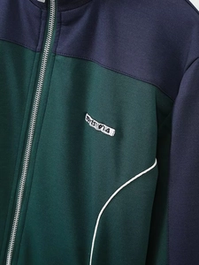 Gros plan sur la fermeture éclair et les coutures de la veste vintage vert et marine