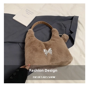 Detail of brown faux fur handbag featuring a central silver butterfly metal ornament