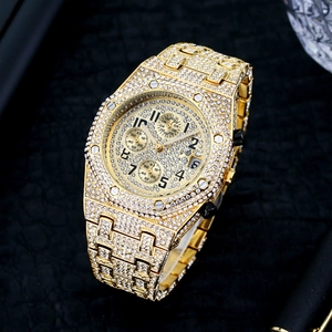 Macro view of gold iced-out men's watch featuring chronograph dials and calendar window