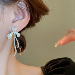 Elegant bow knot earrings with large pearl and sparkling long tassel drop on model