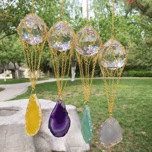 K9 crystal ball with agate slice suncatchers hanging in a lush garden setting