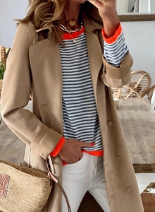 Détail du pull en maille rayé bleu et blanc avec poignets et col orange vif élégant