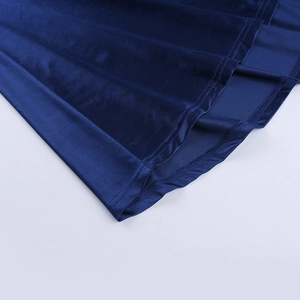 Detail of dark blue velvet dress hem showing precise stitching and smooth fabric luster