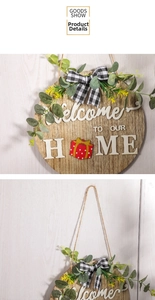 Close-up of wooden Welcome home sign with 3D letters, eucalyptus, and buffalo plaid bow