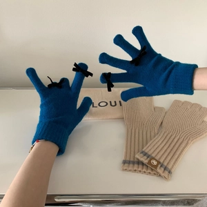 Detail of blue knit gloves with black bow and beige fingerless gloves with grey stripes