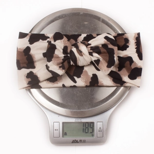 Detailed view of lightweight leopard print baby headband weighing 18.9g on a scale