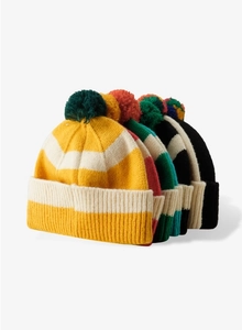 Close-up of colorful striped knit beanies with pom-poms showing thick ribbed texture