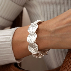 Detail eines silbernen Armbands mit gehämmerten Metallscheiben im Vintage-Stil