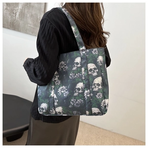 Detail of a casual tote bag featuring skull and floral prints on a dark durable fabric