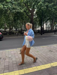 Close-up of oversized light blue striped shirt paired with white cycling shorts and top