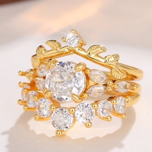 Macro shot of three-piece gold ring set featuring crown design and round crystal gems
