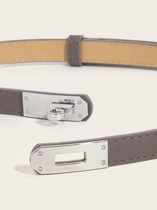 Macro shot of grey Saffiano leather belt featuring a polished silver turn-lock clasp detail