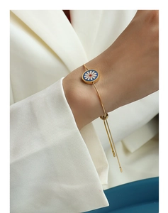 Detail of adjustable 18K gold plated snake chain with blue enamel daisy charm pendant