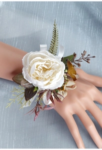 Detailed view of an elegant white artificial flower wrist corsage with silk ribbons