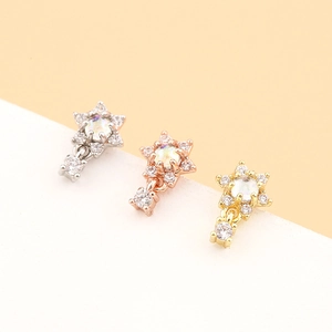 Vue détaillée de boucles d'oreilles étoile en argent, or rose et or avec opale et zircon