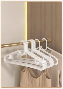 Close-up of slim white anti-slip hangers on a metal rod showing space-saving design