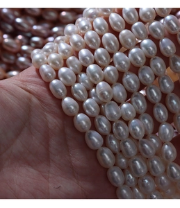 Close-up of 5-6mm natural freshwater rice pearls on hand for DIY jewelry making