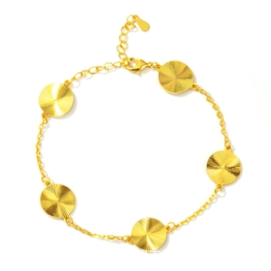 Detailed close-up of golden clover bracelet with sunburst texture and lobster clasp