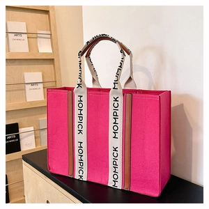 Macro view of hot pink felt tote bag featuring stylish MOMPICK lettered webbing straps
