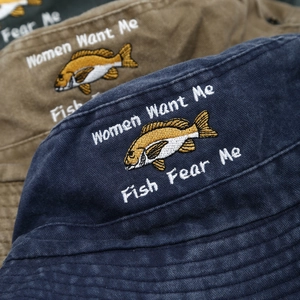 Close-up of embroidered fish and slogan on washed cotton outdoor bucket hat texture
