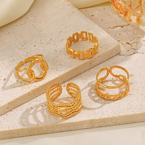 French vintage style gold plated stainless steel crossover ring set on stone background