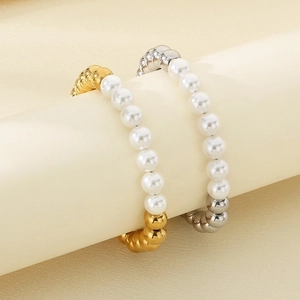 Détail de bagues perlées en or 18 carats et argent avec perles blanches sur support