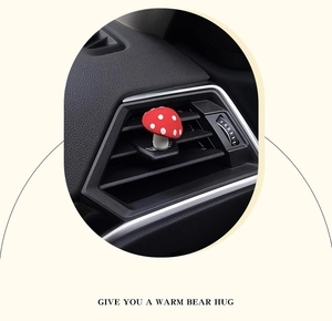 Cute red mushroom car air vent clip accessory mounted on a black dashboard vent