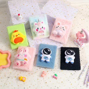 Flat lay of colorful plush cartoon notebooks with 3D animal figures and soft furry covers