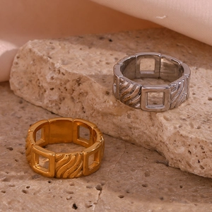 Detailed view of gold and silver open rings with hollow square chain links on stone