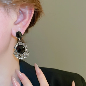 Macro shot of vintage black gemstone earrings with sparkling crystal accents and gold finish