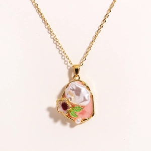Detail of elegant floral pendant with natural freshwater pearl and pink enamel inlay