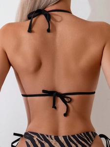 Back view of a bikini set with black halter neck top and zebra print bottoms with side ties