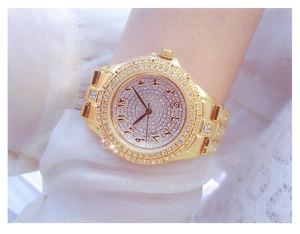Gros plan détaillé d'une montre de luxe dorée avec strass brillants et chiffres arabes