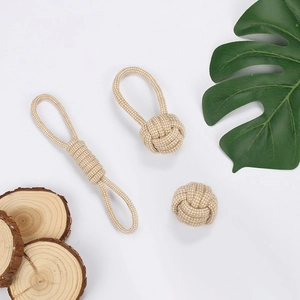 Detail of durable beige cotton rope pet toys with woven ring and knot on wooden background