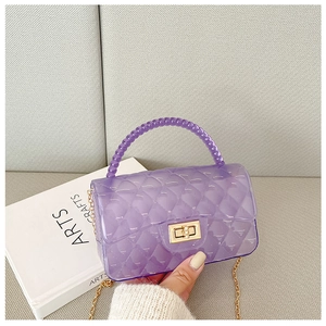 Detail of purple jelly bag with quilted pattern, bead handle, and gold chain strap