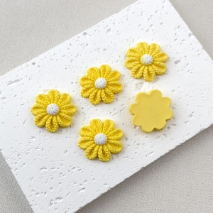 Detailed view of yellow resin flower charms with textured petals and flat backs
