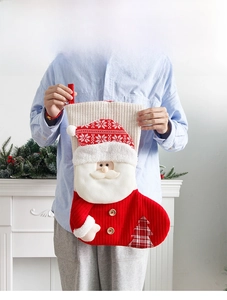 Detail of red and white knitted Christmas stocking with 3D Santa and hanging loop